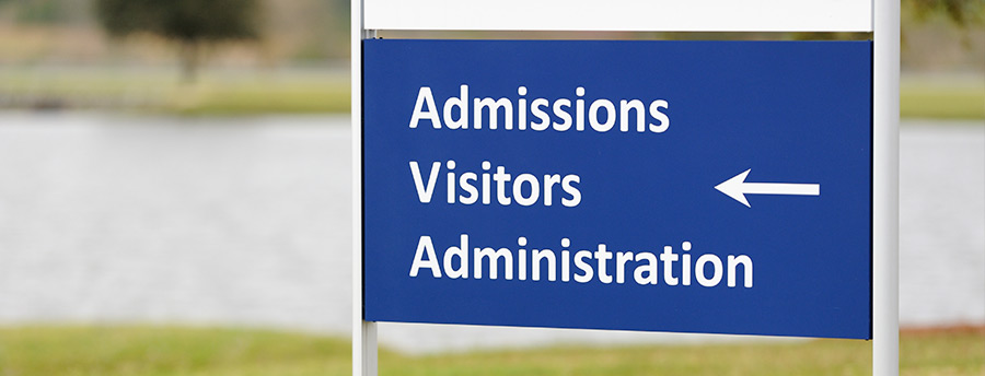 Picture of a sign that reads admissions, visitors, and administration